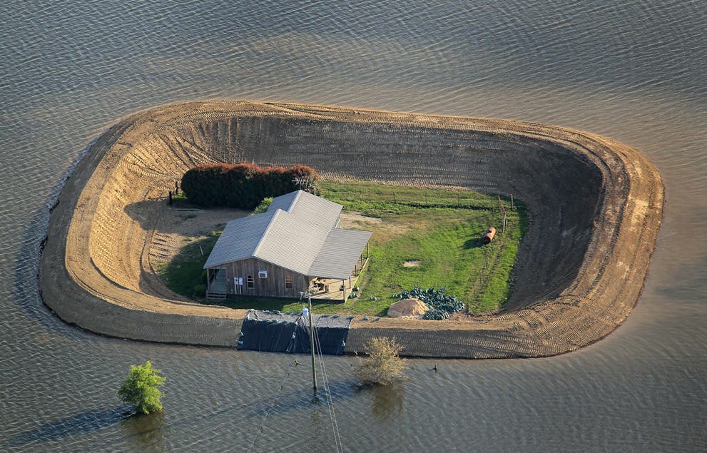 A bastion of dry land protected by a levee in the midst of the flooded Yazee. (c) Scott Olson/Getty Images