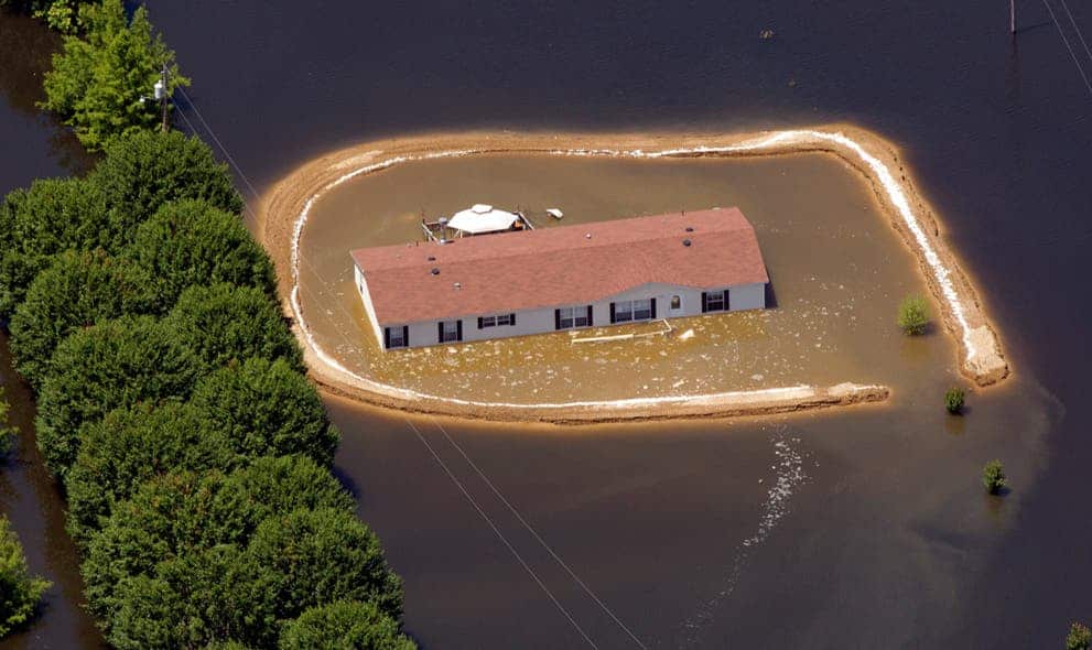 A flooded home surrounded by a makeshift levee that failed in Vicksburg, Mississippi. (c) AP Photo/Dave Martin