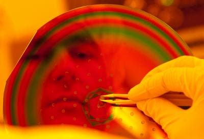 Rice graduate student Ivan Knez holding a semiconductor chip, which contains hundreds of tiny 