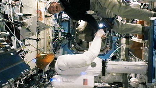 Robonaut and astronaut Daniel Burbank on Feb. 15. engaged in a firm hand shake.  