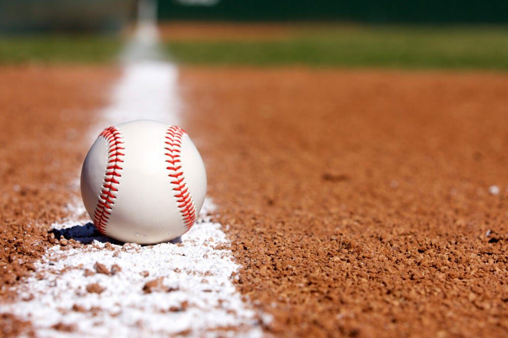 a baseball sits on the infield chalk line