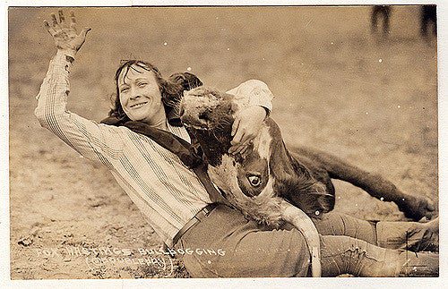 a woman wrangling a cow