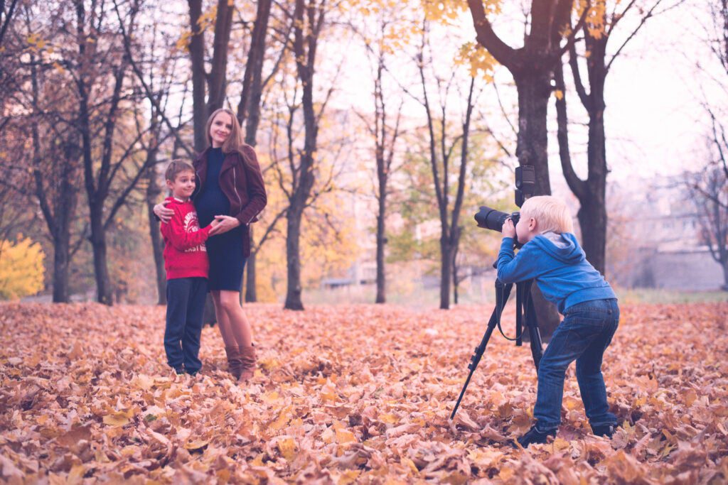 Little blond boy with a big SLR camera on a tripod.