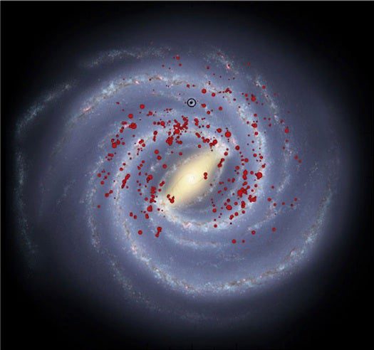 The red spots in this illustration show young, massive stellar objects are distributed in four major arms in the Milky Way. The black bulls-eye shows Earth’s location.