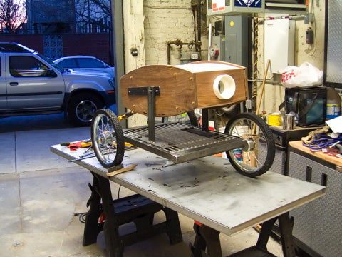 The wheeled projector on a table in a garage.