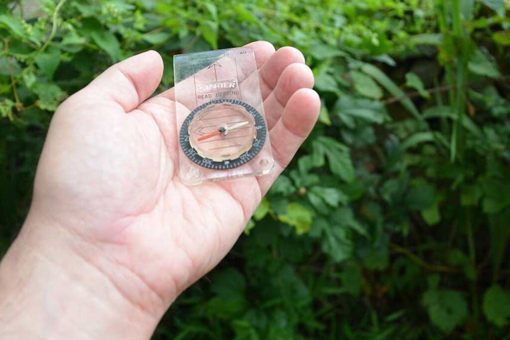 A hand holding a compass