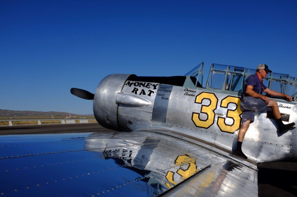 man standing on vintage airplane wing