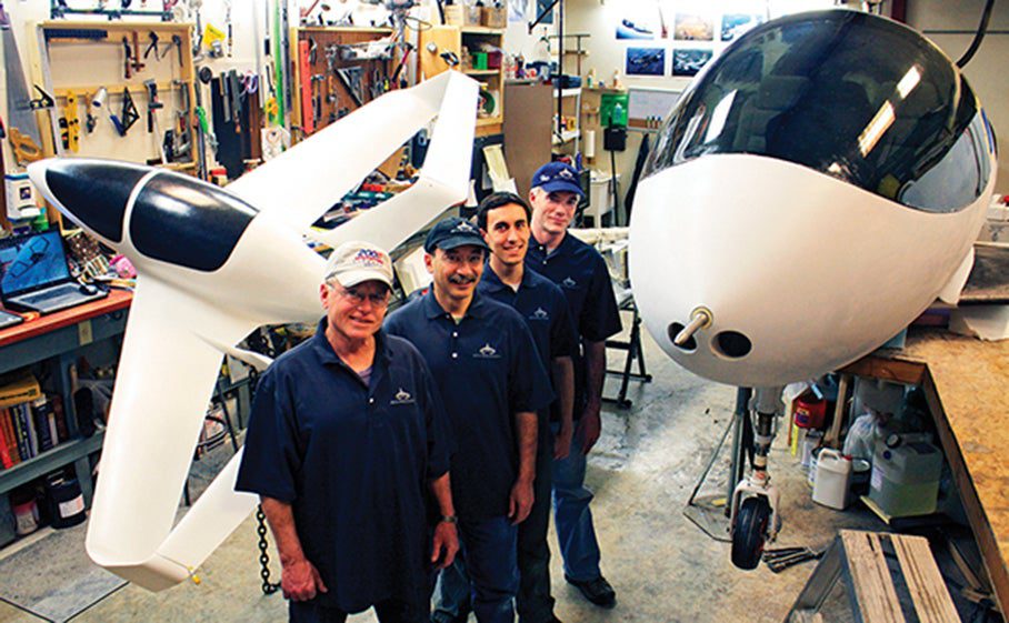 The McGinnis family—Pat, John, and Kyle—and pilot John Paul Noyes [front to back] stand in their Kalispell, Montana, workshop.