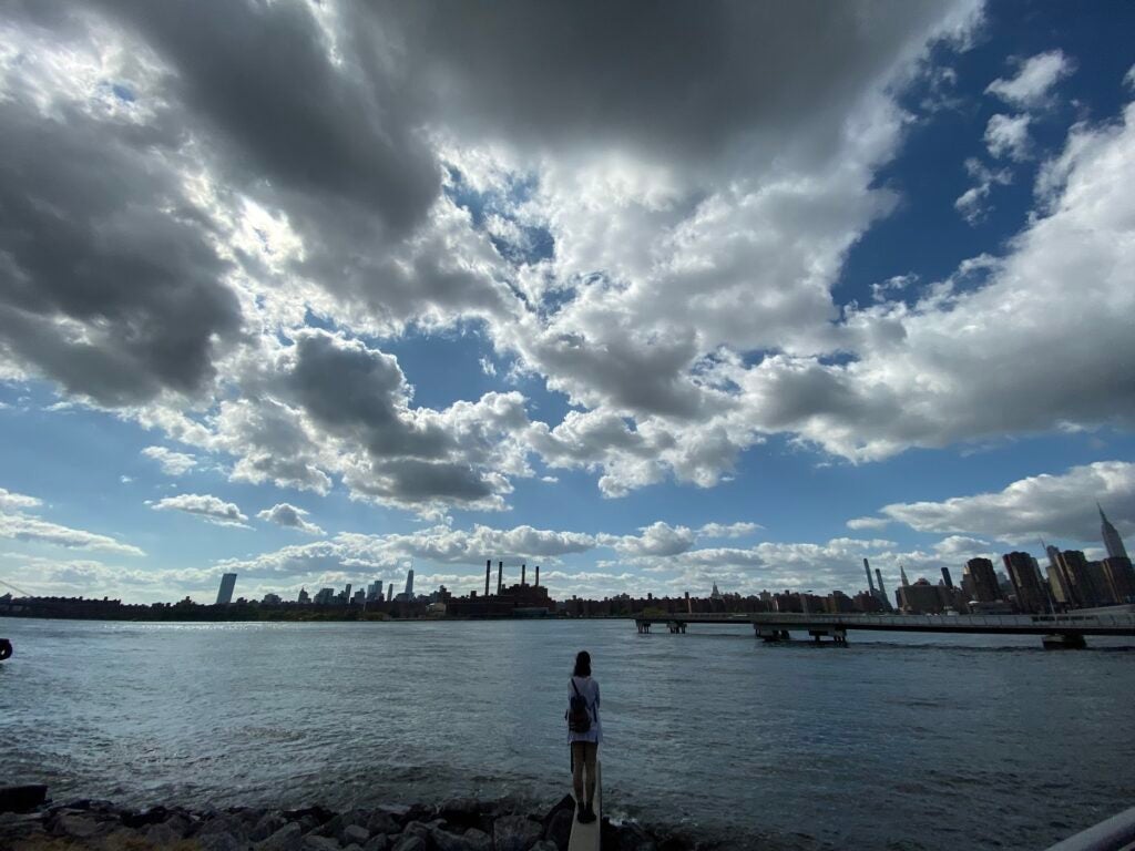 A wide watery landscape with a person's silhouette taken with the iPhone 11 Pro camera