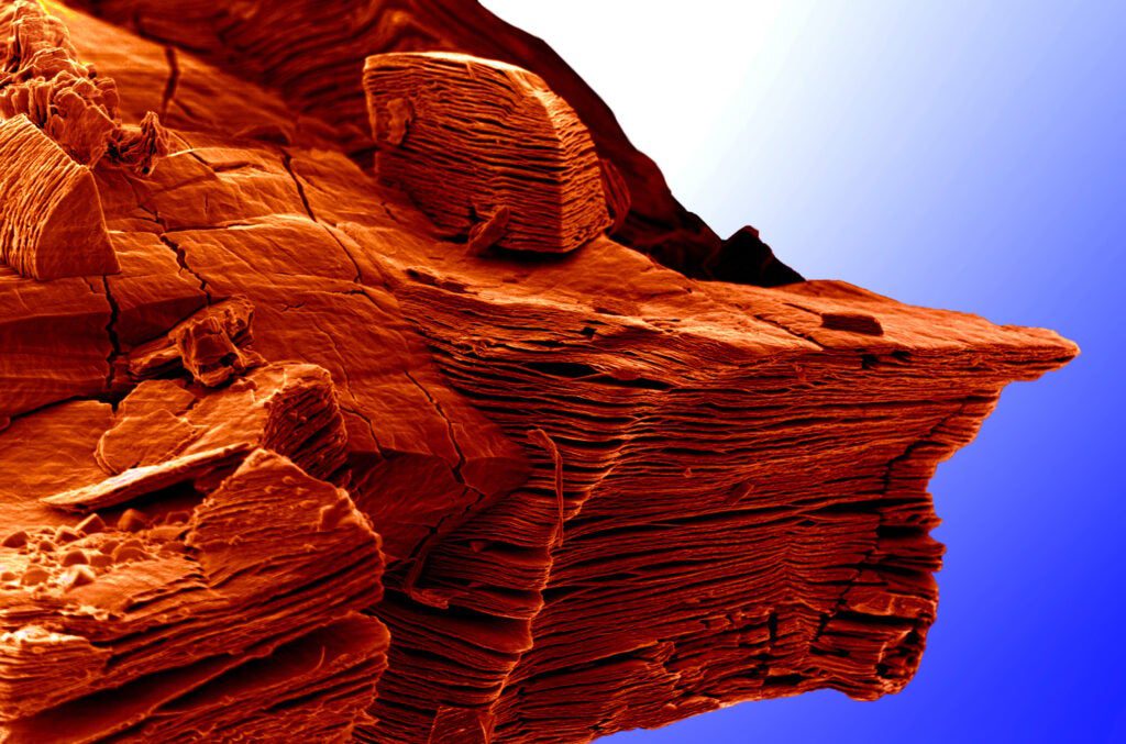 When the layered compound Ti3AlC2 is placed in hydrofluoric acid, the aluminum layers are selectively etched away, resulting in two-dimensional layers of Ti3C2 weakly bonded to each other. This image shows a number of these particles where the aluminum exfoliation is obvious. Like with graphene, individual layers of this titanium-carbon compound can be isolated so their properties can be explored. Ti3AlC2 is a member of a large family of layered solids called MAX phases. Given its similarities with graphene, the scientists who took this image nicknamed the family of 2-D solids "MXene." This image was chosen to represent a new frontier - that is only visible from the cliff - in the world of 2-D materials.