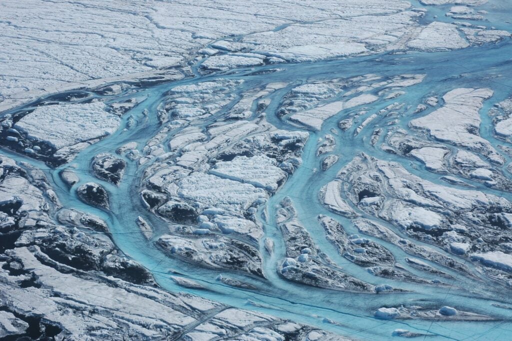 streaks of bright blue water in dirty melting ice