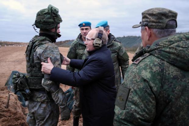 FILE - Russian President Vladimir Putin, center, speaks to a soldier while visiting a military training center of the Western Military District in the Ryazan region of Russia as Defense Minister Sergei Shoigu, right, stands nearby, on Thursday, Oct. 20, 2022. With the fighting in Ukraine now in its third year, Putin hopes to achieve his goals by biding his time and waiting for Western support for Ukraine to wither while Moscow maintains its steady military pressure along the front line. (Mikhail Klimentyev, Sputnik, Kemlin Pool Photo via AP, File)