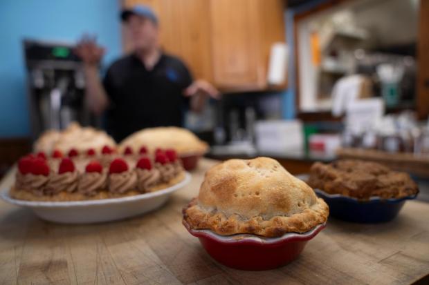 Manager Stephen Jarrett prepares pies on a counter at Michele's Pies, Wednesday, March 13, 2024, in Norwalk, Conn. Math enthusiasts and bakers celebrate Pi Day on March 14 or 3/14, the first three digits of a mathematical constant with many practical uses. Around the world many people will mark the day with a slice of sweet or savory pie. (AP Photo/John Minchillo)