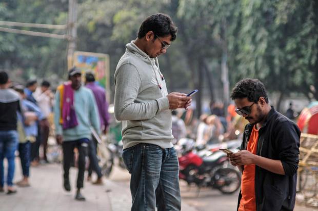 FILE - People engage with their mobile phones at Dhaka University area, Bangladesh, Dec.21, 2023. Artificial intelligence is supercharging the threat of election disinformation worldwide, making it easy for anyone to create fake - but convincing - content aimed at fooling voters. People in countries with low literacy rates, such as Bangladesh and India, are especially vulnerable to social media misinformation. (AP Photo/Mahmud Hossain Opu, File)