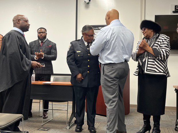 Thomas Davis, center, is pictured pinning a badge on newly sworn in Norristown Police Chief Jacqueline Bailey-Davis on Jan. 2, 2024. Also pictured is Magisterial District Judge Hakim Jones, left, and Bailey-Davis' mother, Pearl Bailey. (Rachel Ravina - MediaNews Group)