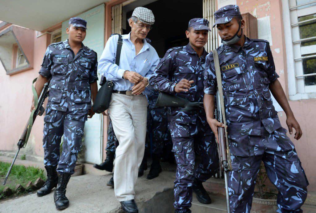 (FILES) In this file photo taken on June 12, 2014 French serial killer Charles Sobhraj (2L) is escorted by Nepalese police to a waiting vehicle after a hearing at a district court on a case related to the murder of Canadian backpacker Laurent Ormond Carriere, in Bhaktapur on June 12, 2014. - Nepal's top court ordered on December 21 the release of Charles Sobhraj, the French serial killer portrayed in the Netflix series 