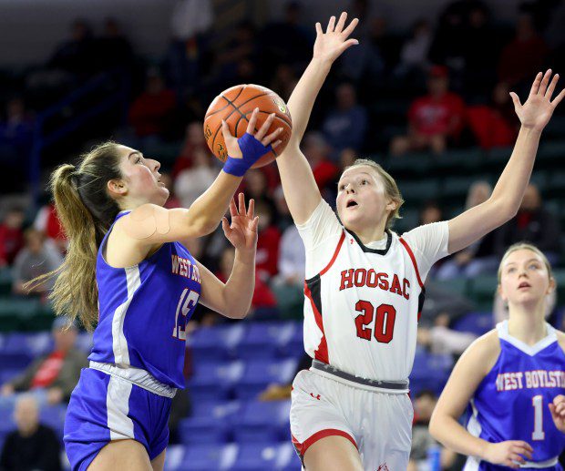 West Boylston's Madison Pitro, left, lays up the ball as Hoosac Valley's Ashlyn Lesure plays defense during the Div. 5 state title girls basketball clash. Hoosac Valley won, 71-53. (Photo by Mark Stockwell/Boston Herald)