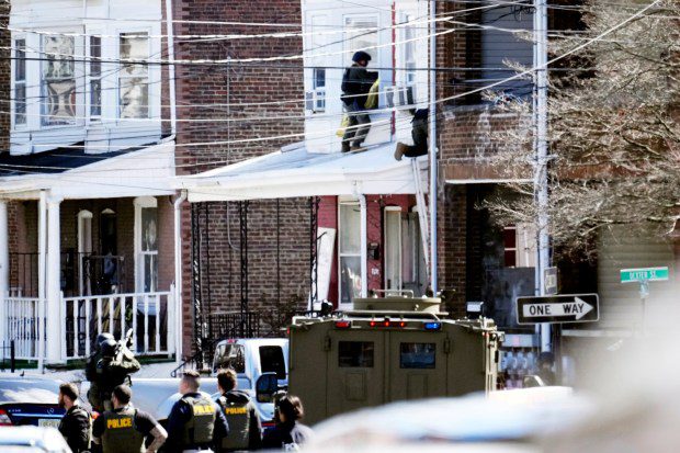 Police surround a home in Trenton, N.J., Saturday, March 16, 2024. A suspect has barricaded himself in the home and was holding hostages after shooting three people to death in suburban Philadelphia. (Matt Rourke/AP)