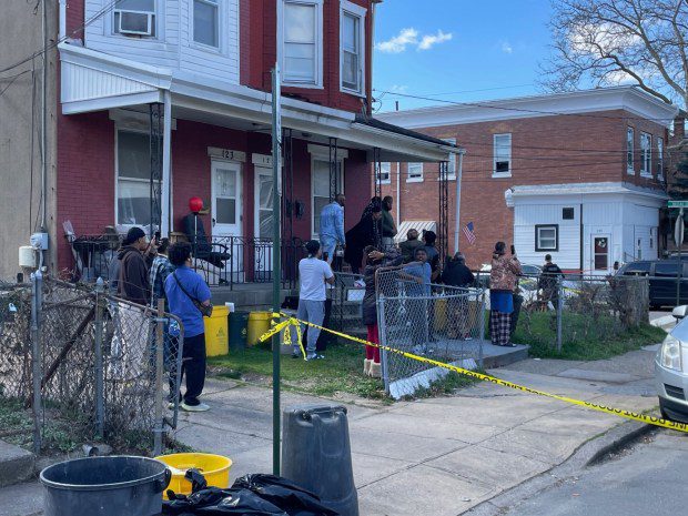 Residents crowded porches and streets Saturday, March 16, 2024, on Phillips Avenue near Dexter Street in Trenton. Andre Gordon Jr., the suspect in two shootings in Bucks County that left 3 people dead, was barricaded inside a home and holding hostages, authorities said. (L.A. Parker/The Trentonian)