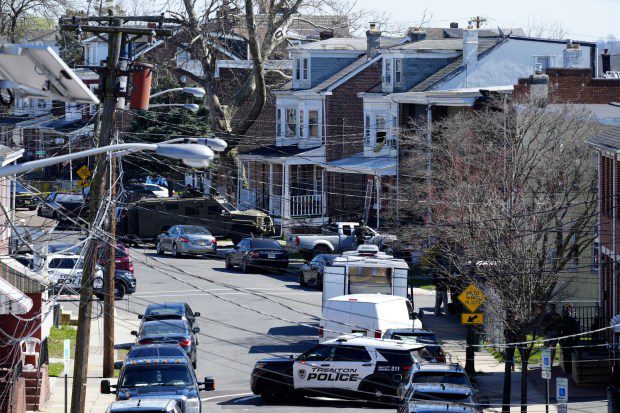 Police surround a home in Trenton, N.J., on Saturday, March 16, 2024. A suspect has barricaded himself in the home after allegedly shooting three people to death in suburban Philadelphia on Saturday, authorities said. (Matt Rourke/AP)