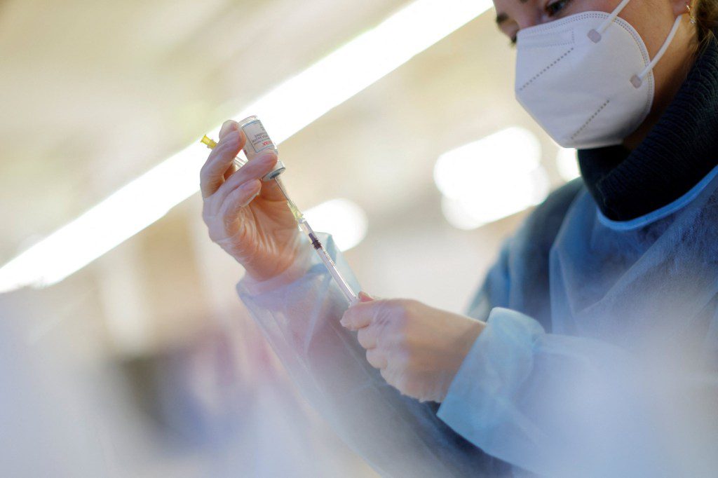 A nurse prepares a booster dose of the Moderna COVID-19 vaccine in Germany