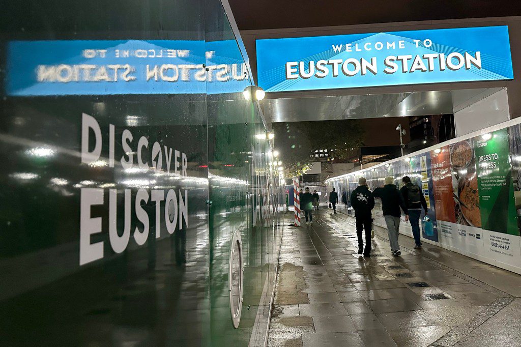 LONDON, ENGLAND - OCTOBER 19: People navigate their way around hoardings surrounding the construction site for the HS2 High speed rail terminus at Euston Station on October 19, 2023 in London, England. HS2 work at Euston was paused earlier this year due to rising costs. Following the announcement by Prime Minister Rishi Sunak to axe plans for HS2 to run from Birmingham to Manchester, a new development company, separate from HS2, will be appointed to manage the delivery of the Euston project, which will only go ahead with private investment. (Photo by Jim Dyson/Getty Images)