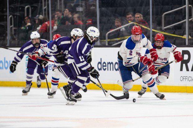 Tewksbury's Anthony Difranco, right, battles for the puck against Boston Latin's Tyler O'Brien. Tewksbury was defeated, 4-2, in the Div. 2 boys hockey state title game in Boston. (James Thomas photo)