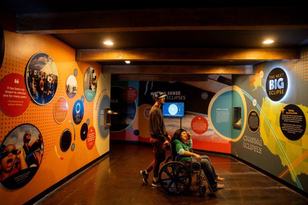 Zachary and Kelly Kocinski look at the "Chasing Eclipses" exhibit, March 13, 2024, at the Adler Planetarium in Chicago. (Vincent Alban/Chicago Tribune)