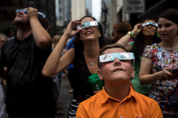 People watch the partial solar eclipse from Daley Plaza in downtown Chicago on Aug. 21, 2017.(Alexandra Wimley/Chicago Tribune)