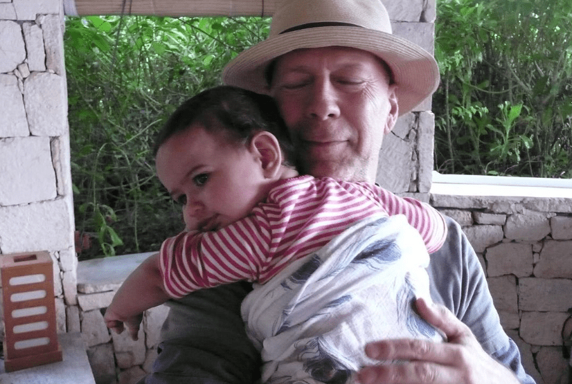 Bruce Willis hugging a young child