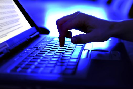 Close up of a hand on a laptop keyboard