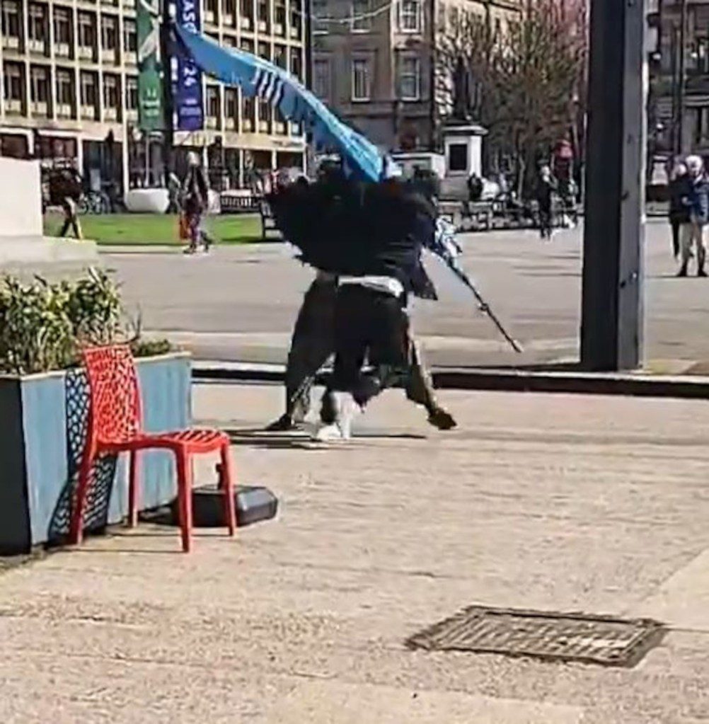 man chucks flagpole at another man