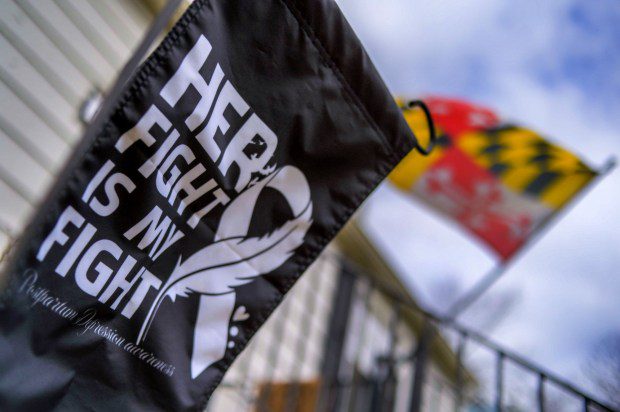 An outdoor banner proclaims, "Her Fight is My Fight, Postpartum Depression Awareness" outside the home of Kyra Vocci, to spread the message about postpartum depression regarding her sister Andrea Kolbe, who committed suicide last Dec. shortly after giving birth. (Karl Merton Ferron/Staff)