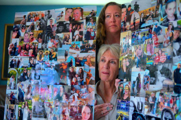 Kyra Vocci stands above her mother, Lisa Kolbe, posing with poster boards filled with a collage of photos of Andrea Kolbe, who committed suicide last Dec. while fighting postpartum depression. (Karl Merton Ferron/Staff)