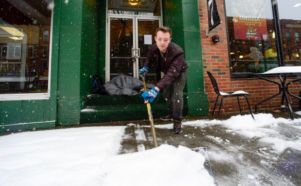 Mikey Reynolds, an employee at The Works on Main Street in Brattleboro, Vt., shovels the sidewalk in front of the restaurant during the snow storm on Saturday. (Kristopher Radder /The Brattleboro Reformer via AP)