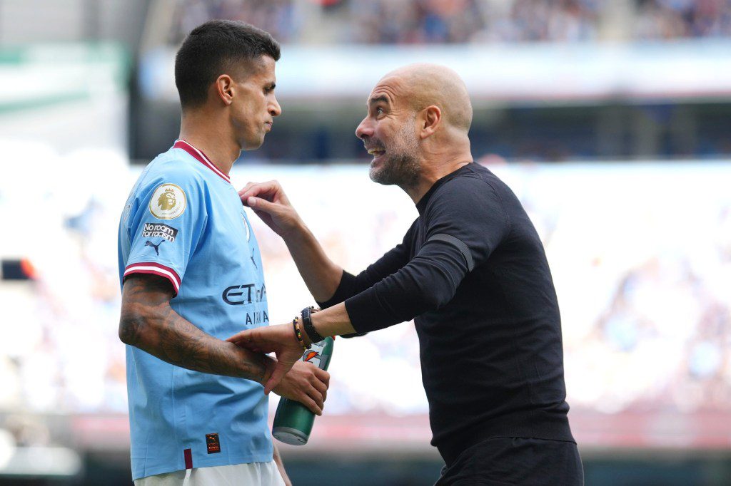 Pep Guardiola, Manager of Manchester City, gives instructions to their side Joao Cancelo of Manchester City