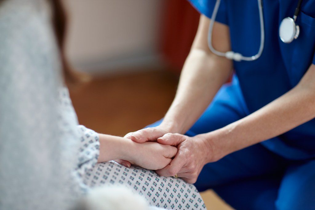 Nurse holding patient's hand