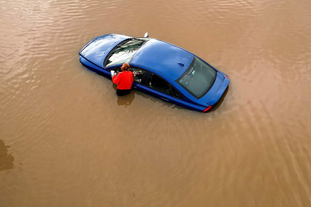 WORCESTER, ENGLAND - JANUARY 03: A woman checks on a flooded car in car park in Worcester city centre on January 03, 2024 in Worcester, England. The Met Office has issued over 300 warnings for flooding in parts of the UK in the wake of Storm Henk. Towns along the River Severn had already experienced flooding following another recent storm. (Photo by Christopher Furlong/Getty Images)