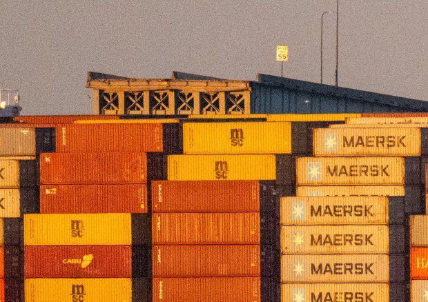 A speed limit sign is seen  above the Maersk container ship Dali and the remains of the collapsed Francis Scott Key Bridge. The massive container ship was adrift early Tuesday as it headed toward the iconic Francis Scott Key Bridge, losing power before colliding with one of the bridge's support columns. (Jerry Jackson/Staff)