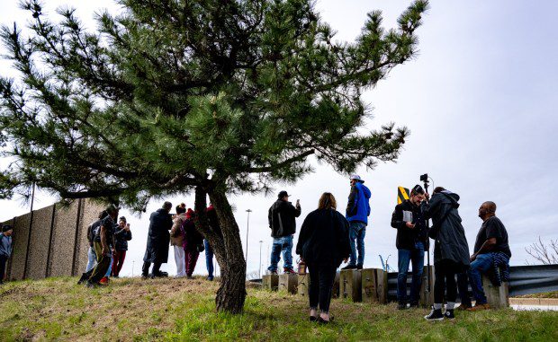 Dundalk residents stand along Browning Highway to get a look at the remains of the collapsed Francis Scott Key Bridge. The massive container ship Dali lost power before colliding with one of the bridge's support columns early Tuesday. (Jerry Jackson/Staff)