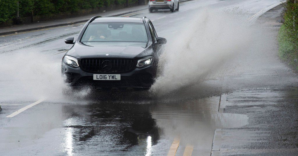 Car drives through puddle