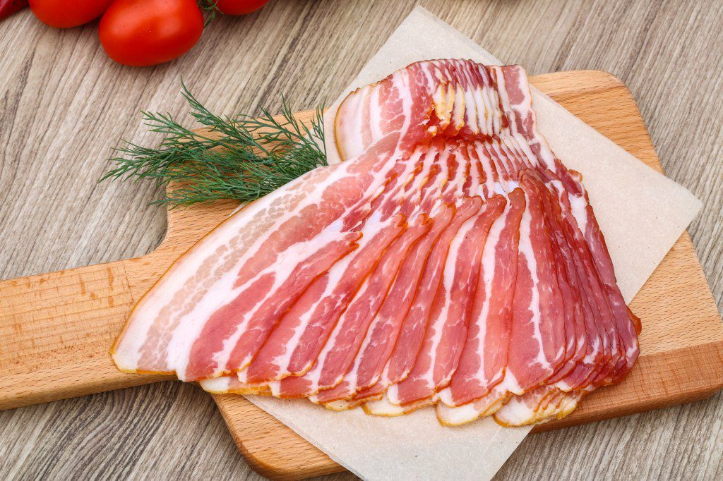 Fresh cold sliced bacon with dill branch on the wood background; Shutterstock ID 301366133; purchase_order: -; job: -; client: -; other: -