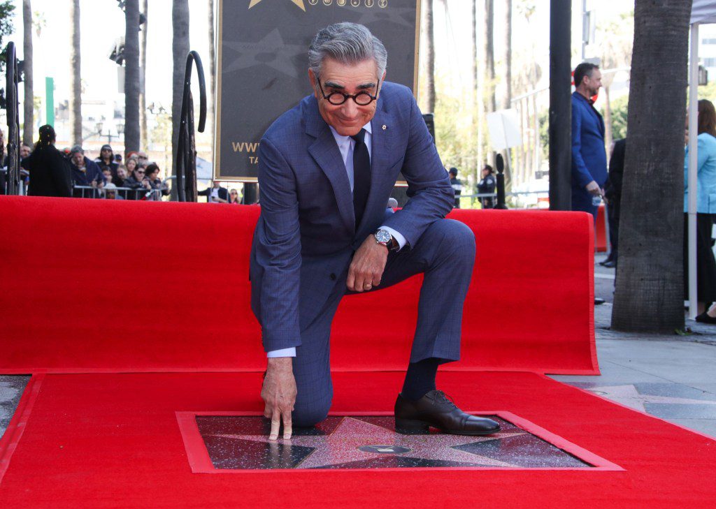 Eugene Levy touching his star on the Hollywood Walk of Fame