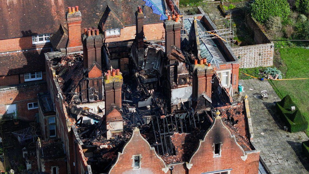 The owner manages to escape with the Dog his phone in his pants as the blaze ripped through the property. https://youtu.be/vm57dEYBXqc. GV https://youtu.be/CZAsw9qh_vM Interview with Fire commander A devastating fire has erupted at Gennings Park, a historic Grade II listed house located near Hunton, Kent, engulfing the first floor and roof space of the three-storey property. Sixteen fire engines, along with a height vehicle, are currently on the scene, battling the blaze. Firefighters, equipped with breathing apparatus, are tirelessly fighting the fire using main jets amidst difficult conditions. Despite the challenges, they have been working diligently to salvage belongings from the property. The technical rescue team is also in attendance due to the partial collapse of the building. Aerial view of building fire with firefighting efforts. Fortunately, there have been no reports of any injuries resulting from the fire. However, the cause of the blaze remains unknown at this time and is under investigation. Aerial view of fire-damaged manor with emergency response. Gennings Park, sometimes referred to as Gennings House or Gennings Court, holds a rich historical significance. Built between 1727 and 1745, the property has been associated with notable figures throughout history. Occupants have included Sir Walter Roberts, 6th Bt, and his daughter Jane Roberts, who married George Beauclerk, 3rd Duke of St Albans. Later, it was inhabited by the Liberal politician Henry Campbell-Bannerman and his family. https://youtu.be/vm57dEYBXqc Over the years, Gennings Park has seen various occupants, including Conservative MP Sir Frederick Seager Hunt, 1st Bt, and his wife. The property has changed hands multiple times, with its grandeur and elegance attracting attention from both residents and investors alike. Firefighters tackling blaze at historic building. As firefighters continue their efforts to contain the blaze, the community remains on edge, hoping for a swift re