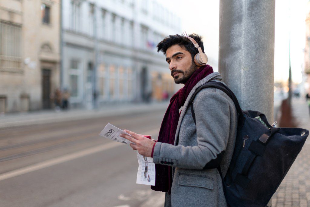 Man listening to music at the bus stop