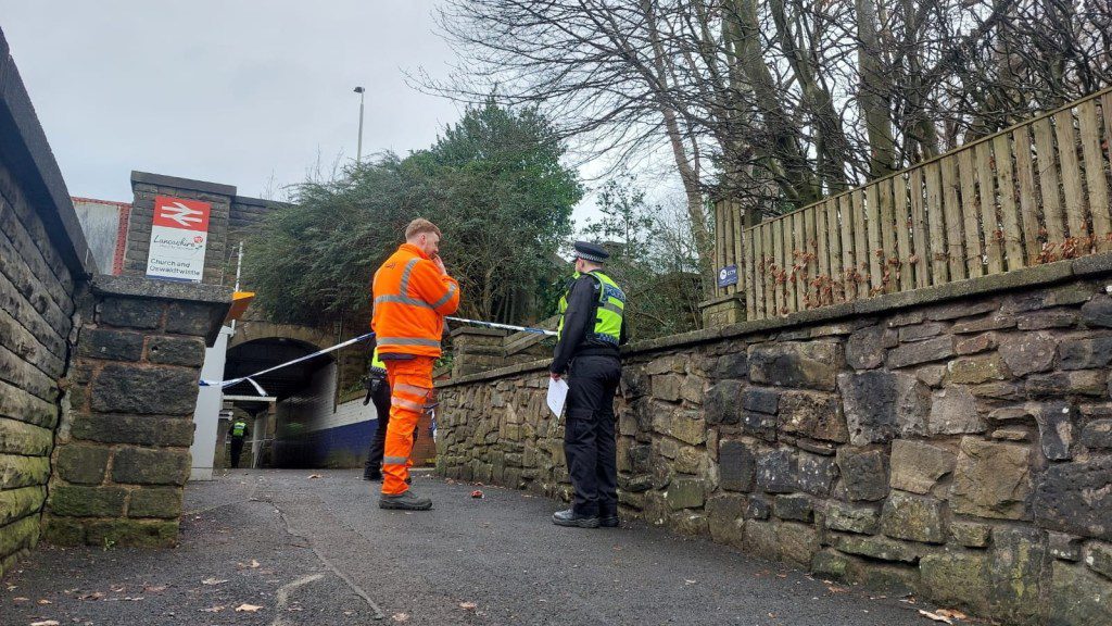 A police officer speaks with a worker from Network Rail outside the station in Market Street