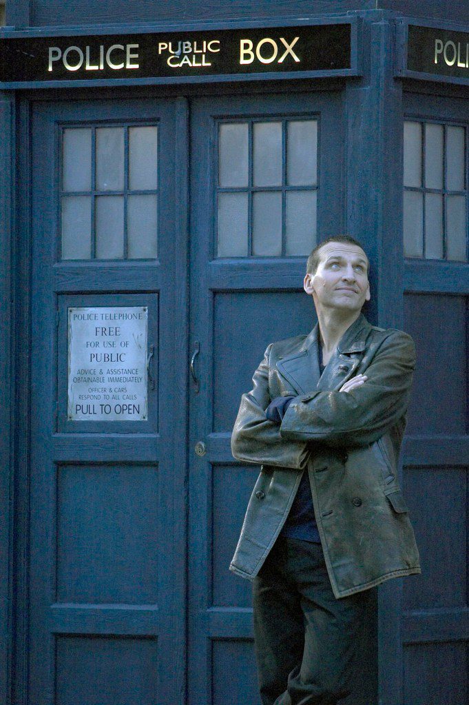 CHRISTOPHER ECCLESTON standing in front of the tardis