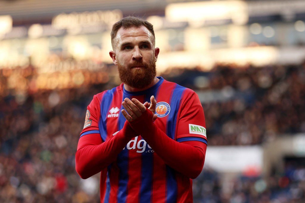 Theo Widdrington of Aldershot Town applauds the fans