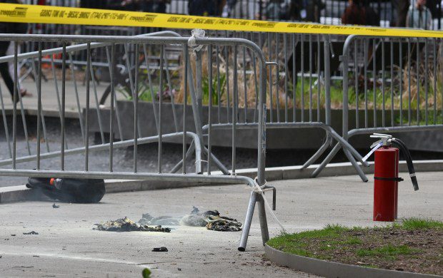 Fire extinguishers (R) and a backpack (L) are left at the park across from Manhattan Criminal Court in New York City after a man reportedly set himself on fire during the trial of former President Donald Trump Friday. (Photo by ANGELA WEISS/AFP via Getty Images)