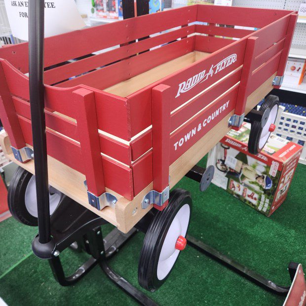 Red wooden wagon on display in a store